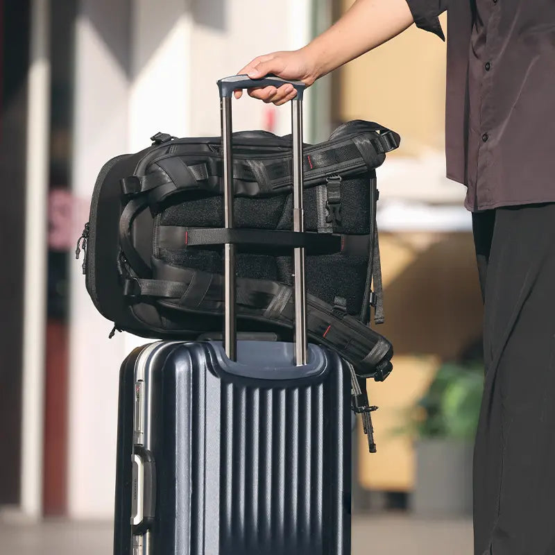 Ulanzi BP10 camera backpack mounted on a suitcase handle, ready for travel.