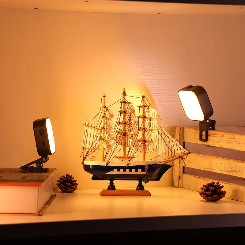 Ulanzi U60 RGB video light casting warm light on ship model decor in a display.