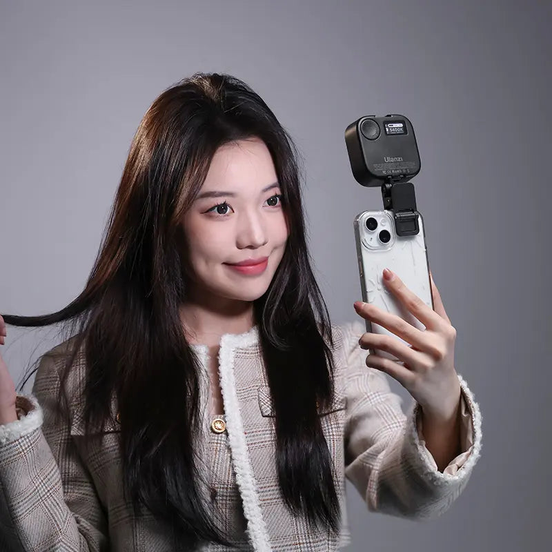 Woman taking a selfie with Ulanzi U60 LED light mounted on smartphone.