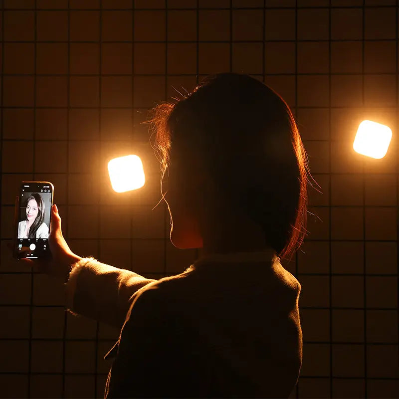 Person taking a selfie with Ulanzi U60 RGB video lights in the background.