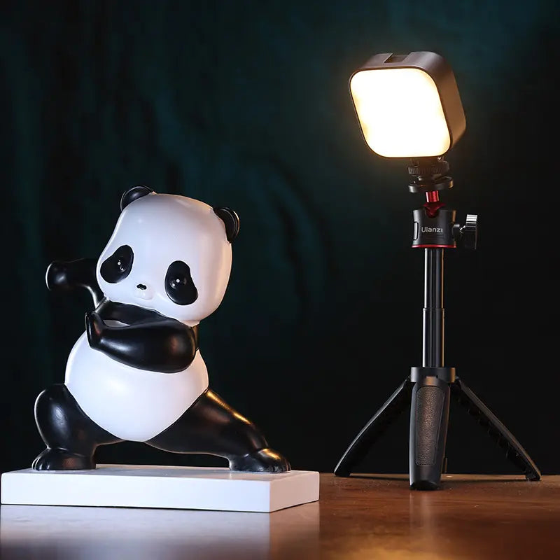 Ulanzi U60 RGB video light illuminating a panda figurine on a wooden table.