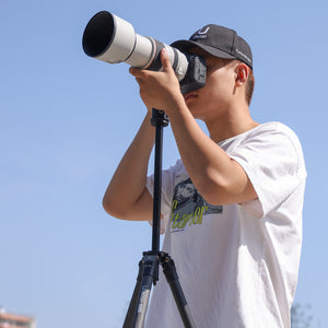 Ulanzi MT-60 carbon fiber tripod with camera. Person using the tripod outdoors.