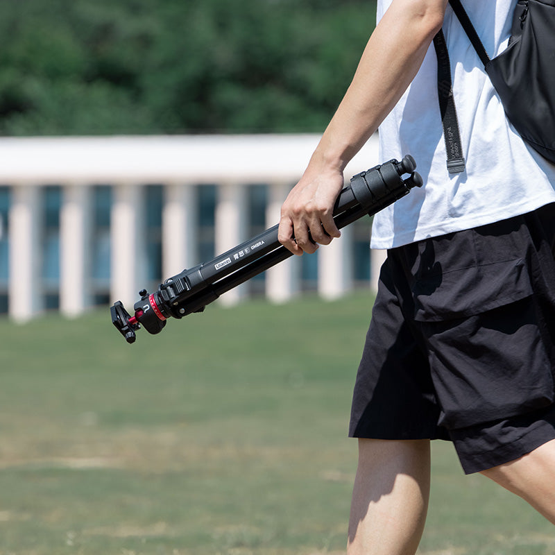 Person carrying Ulanzi Ombra YING Travel Tripod outdoors