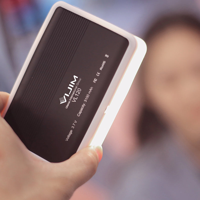 Person holding Ulanzi VIJIM VL120 Bi-Color LED Video Light showcasing back features and USB-C port.