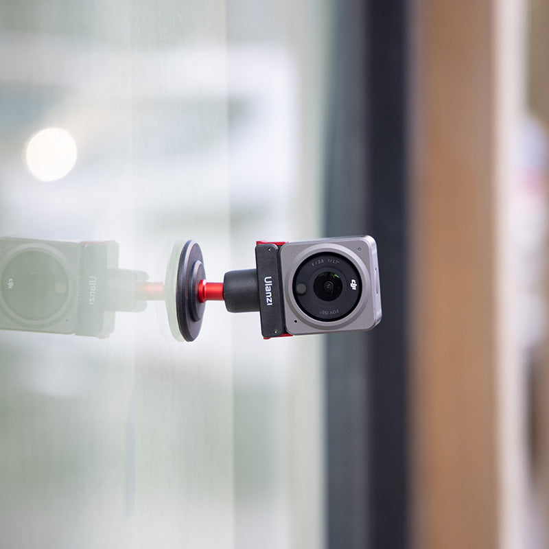 Ulanzi U-170 Magnetic Quick Release Head with DJI Action Camera, attached to glass surface.