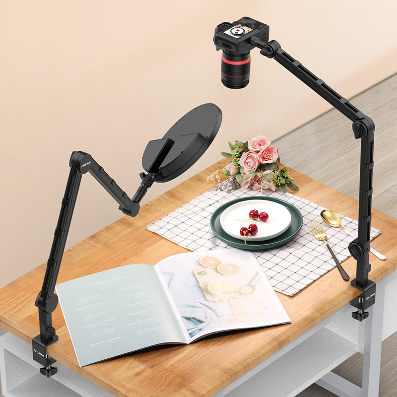 Ulanzi LS25 desk arm supporting a camera over a book and plate on a wooden table.