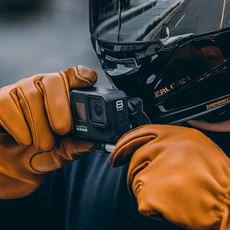 Person wearing gloves holding GoPro 8 camera for action shooting