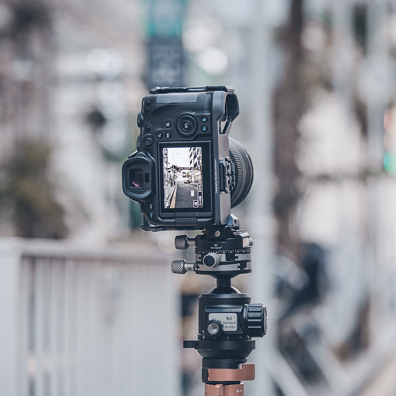DSLR camera on tripod with viewfinder displaying urban scene