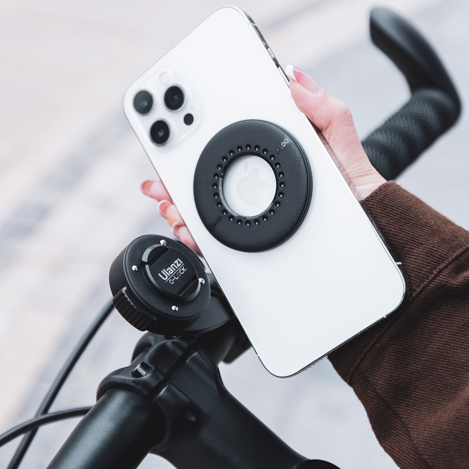 Smartphone with Ulanzi O-LOCK sticker on bicycle handlebar mount